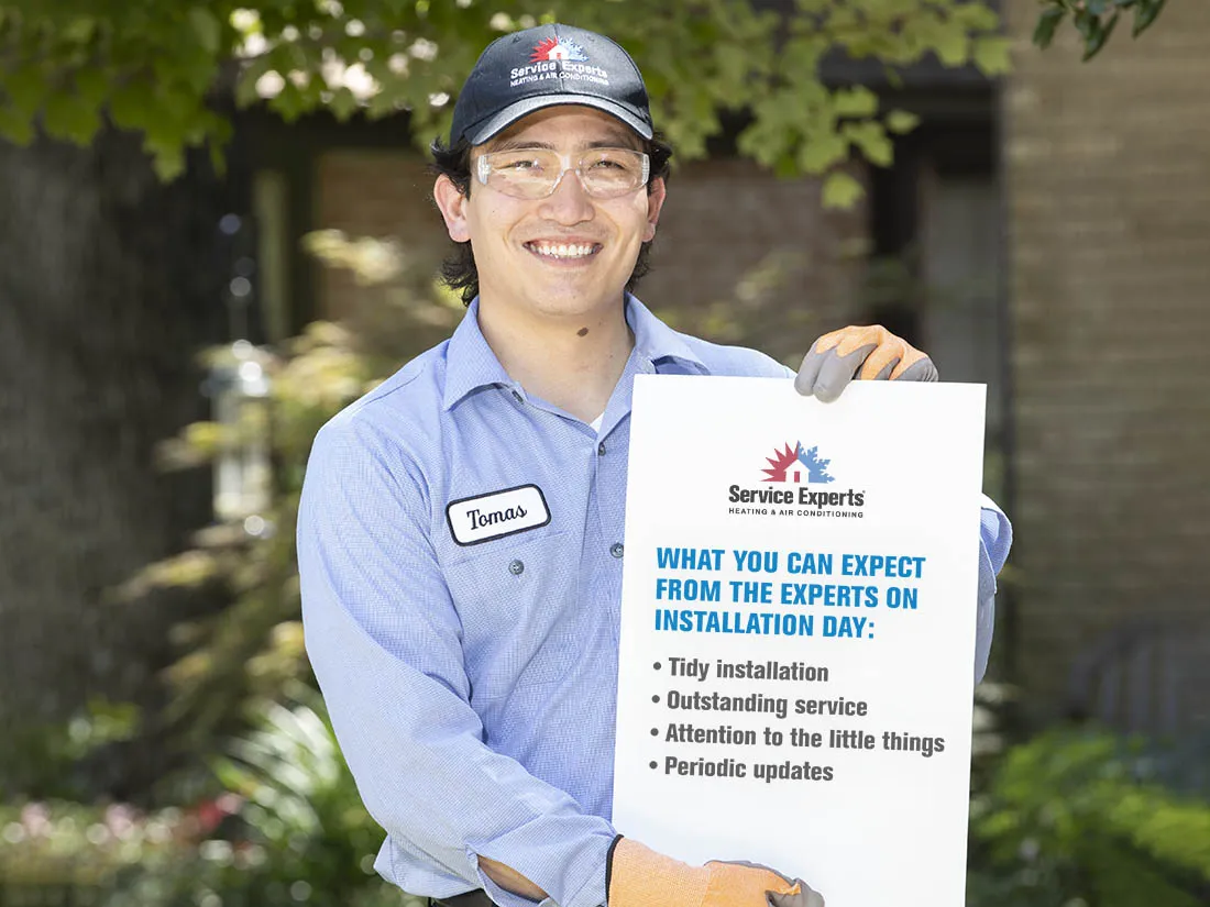 Service Experts tech holding a sheet with installation day expectations